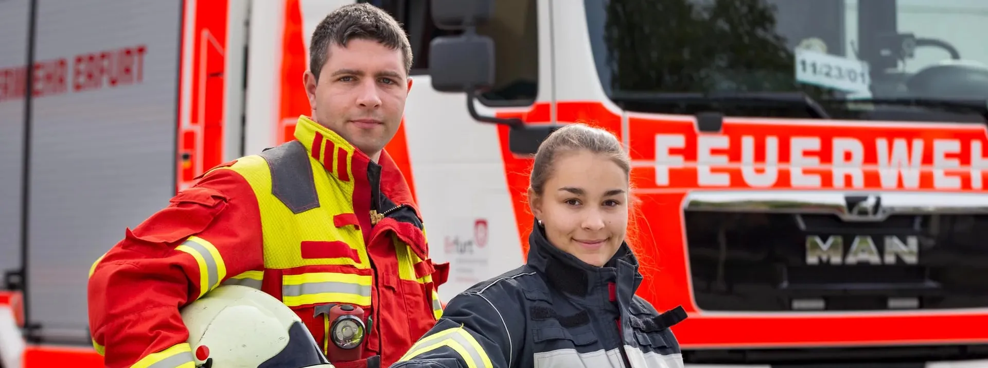 Zwei Personen vor einem Feuerauto